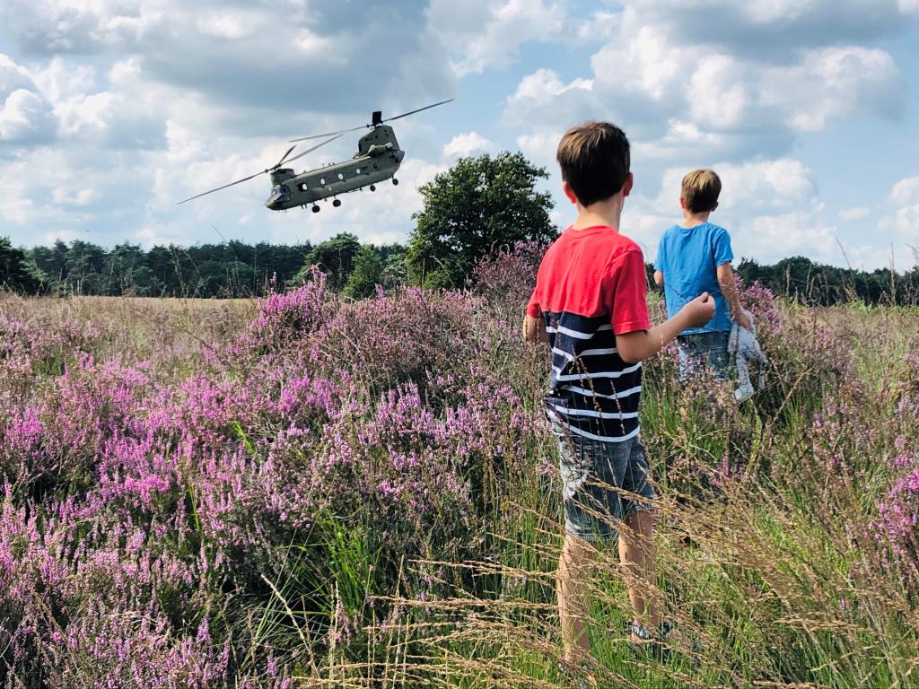 jongens op de oirschotse heide met op de achtergrond een militaire helikopter